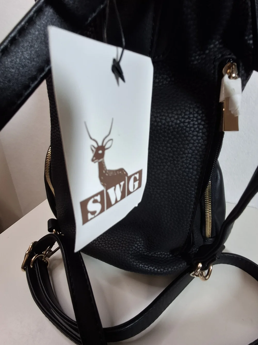 SWG Black Pebbled Sling Barrel Backpack with Gold Accents